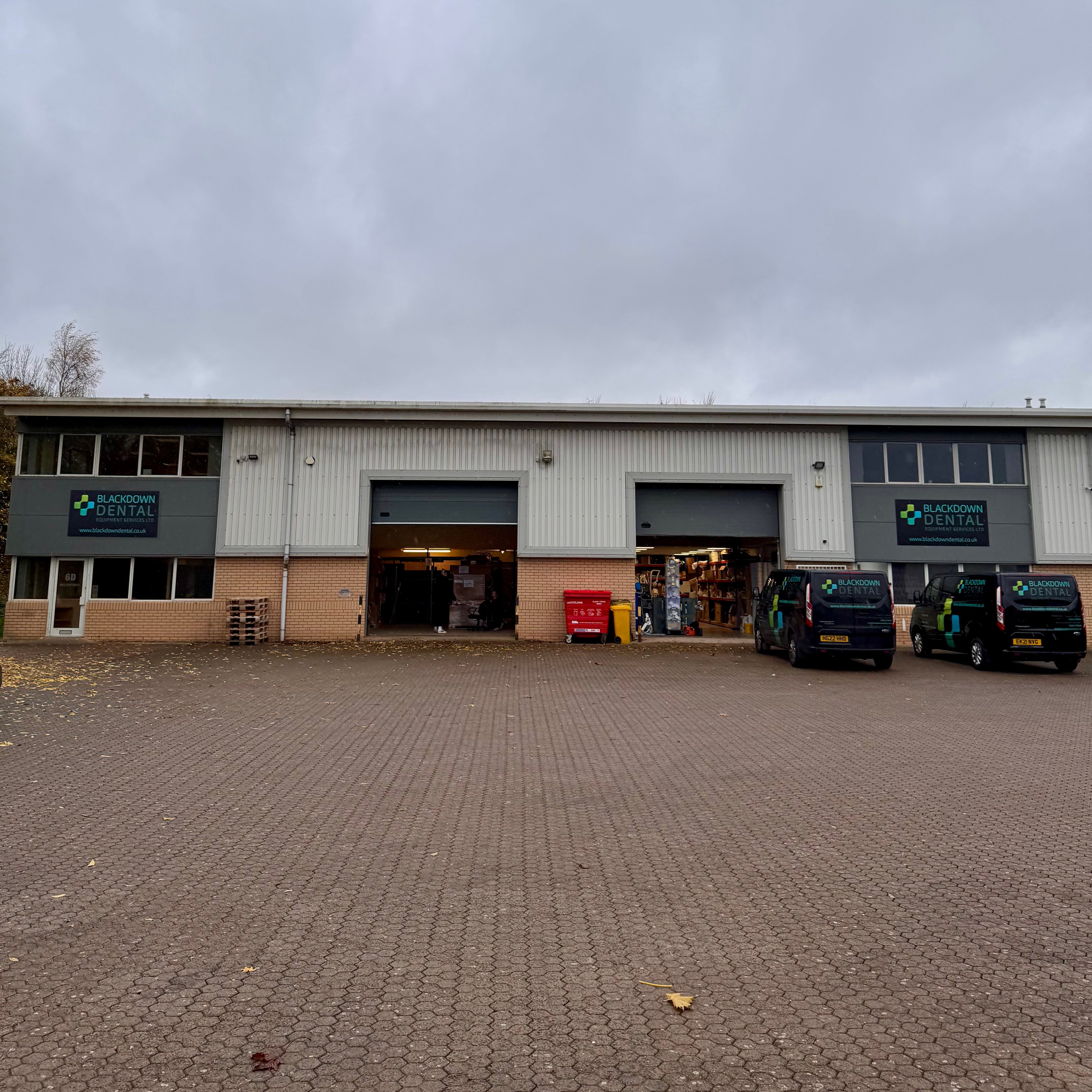 Large industrial building with open garage doors on a cloudy day